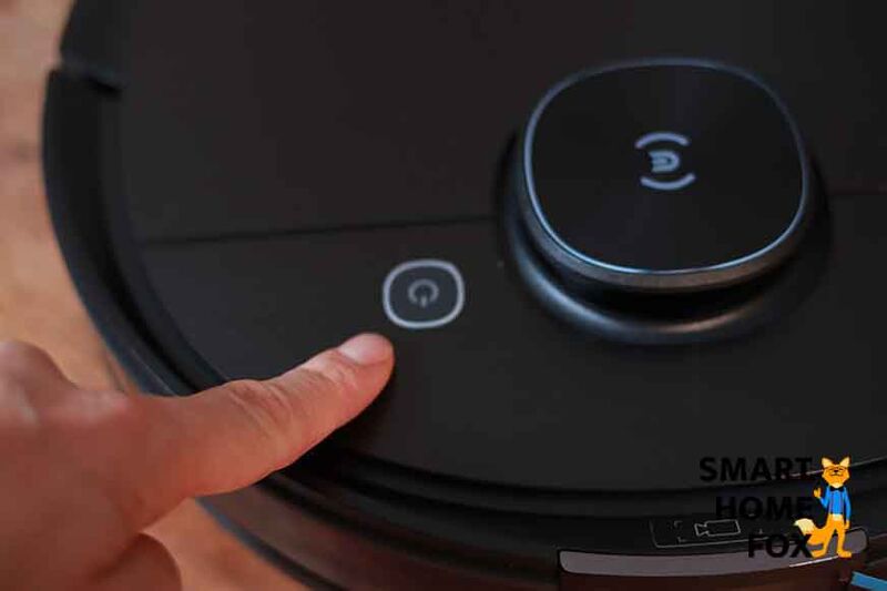 Ein Finger zeigt auf die Start /Stopp Taste des Ecovacs Deebot T9 AIVI